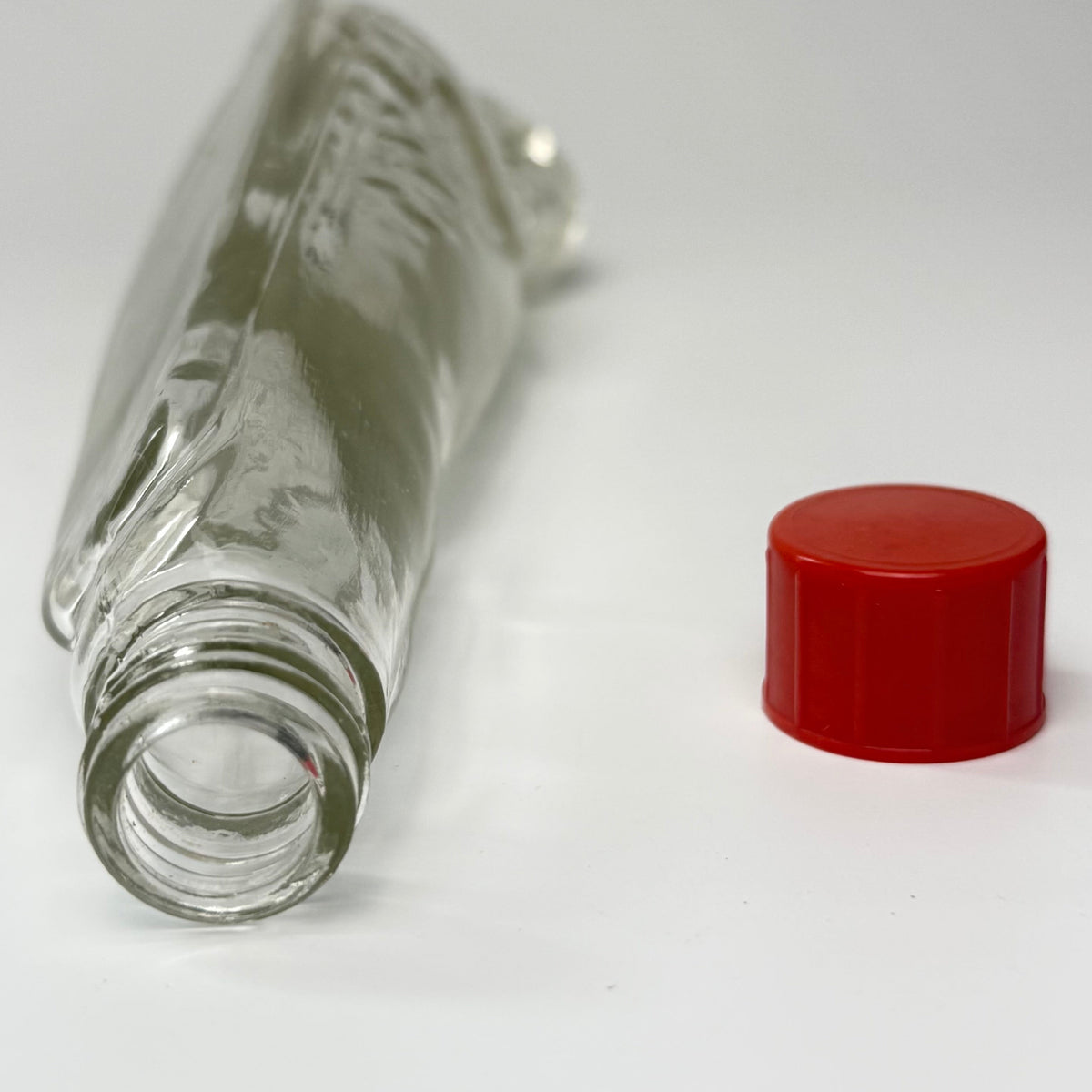 Vintage tysk figurflaske i klart formpresset glas, udformet som en liggende sæl – Seehund.

Flasken har detaljeret relief med sælens hoved, luffer og krop. Hoved og snude er udført i massivt glas.

Denne type figurflaske blev fremstillet i Tyskland som emballage til spiritus. Tilsvarende eksemplarer ses med originale etiketter mærket bl.a. “Seehund” og “Deutsches Erzeugnis”. Producenten af dette eksemplar er ikke identificeret med sikkerhed.

Med original/lignende ældre rød skrueprop i plast med kork på ind